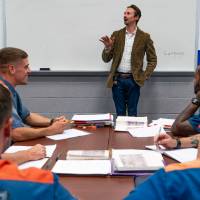 Students seated in front, instructor standing at whiteboard